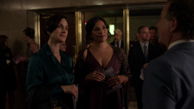 Carrie-Anne Moss as Jeri Hogarth and Sarita Choudhury as Kith Lyonne at a swanky gathering.